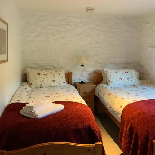 a bedroom with two beds with red and white sheets at Tithe Barn 2 - Abercelyn Cottages - Llanycil - Bala - Gwynedd - LL23 7YF - UK in Llanycil