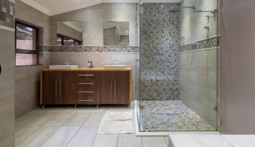 a bathroom with a shower and two sinks and a shower at Mancave Luxury Homes in Alberton