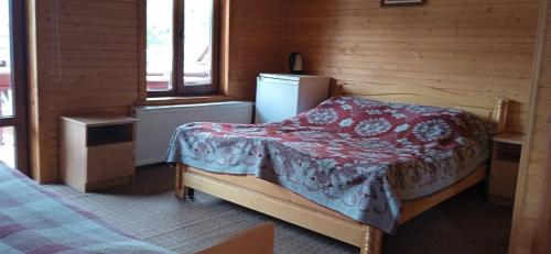 a small bedroom with a bed and a refrigerator at Бойківський двір in Yasenitsa Zamkova
