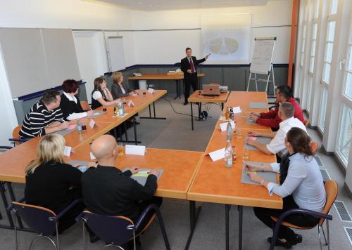 a group of people sitting around tables in a classroom at Landhotel Gasthof Krone in Kupferzell