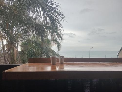 two cups on a table with a view of the ocean at The Sync Inn in Gqeberha