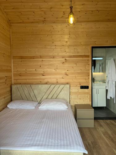 a bedroom with a bed and a wooden wall at Cascade Resort Sevan in Sevan
