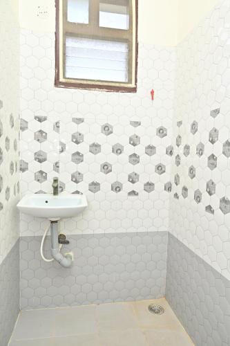 a bathroom with a sink and a shower at Hotel Siddveer Grand in Guntūr