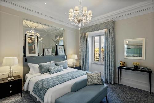a bedroom with a large bed and a chandelier at The St. Regis Rome in Rome