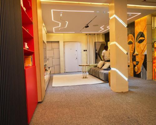 a man standing in a bedroom with a bed and a table at Capediem luxury apartment in Oba Ile