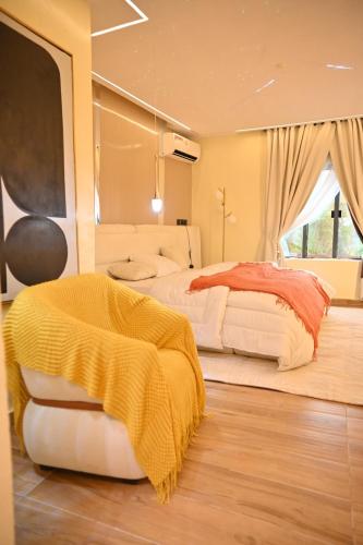 a bedroom with two beds with a yellow blanket at Capediem luxury apartment in Oba Ile