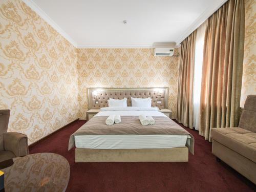 a hotel room with a bed and a couch at Grand Capital Hotel in Tashkent