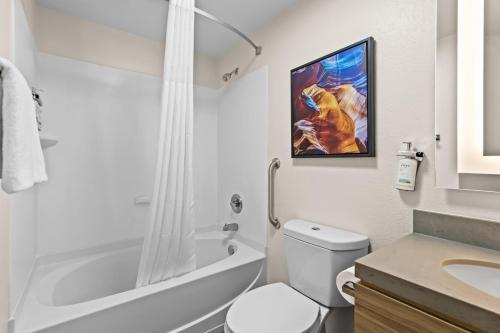 a white bathroom with a toilet and a sink at Candlewood Suites Flowood, MS by IHG in Luckney