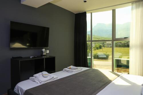 a bedroom with a bed and a large window at Hotel Impex in Peje