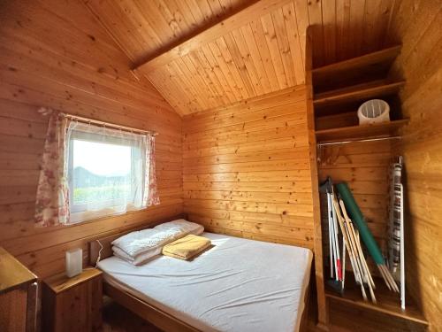 a bedroom with a bed in a wooden cabin at Domki Letniskowe Krakus in Rusinowo