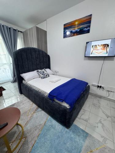 a bedroom with a bed with a black headboard at Peace Nest bamburi in Mombasa