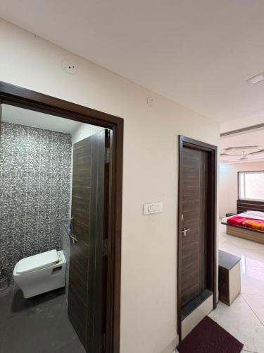 a bathroom with a toilet and a bed in a room at Sakkhar Palace in Indore
