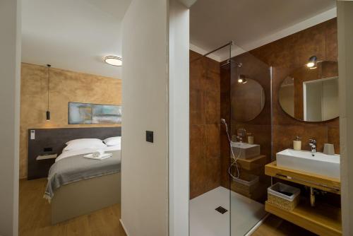 a bedroom with a bed and a bathroom with a sink at Villa Mochi by IstriaLux in Pićan
