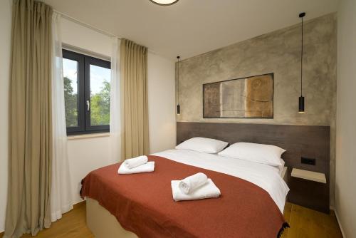 a bedroom with a bed with two white towels on it at Villa Mochi by IstriaLux in Pićan