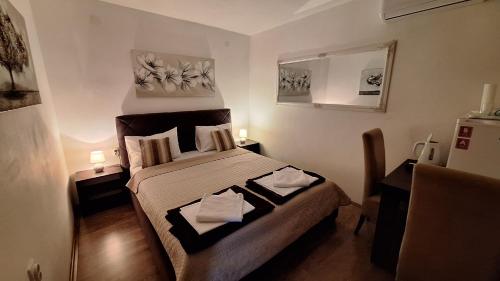 a bedroom with a bed with two towels on it at Apartments & Dream Rooms in Niš