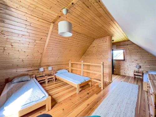 a room with two beds in a wooden cabin at Domki Wczasowe Mielenko in Mielenko
