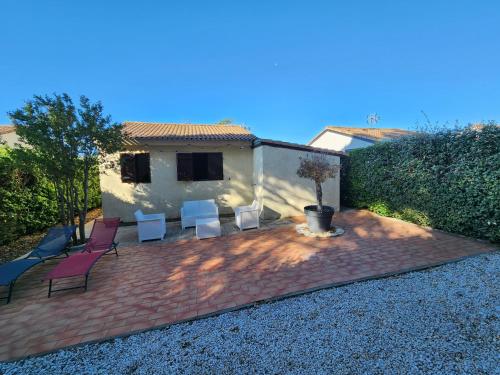 a patio with several chairs and a house at Maison à la mer in Vendres