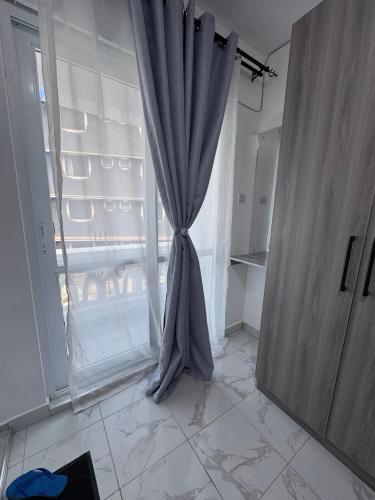a curtain in a room with a window at Peace Nest bamburi in Mombasa
