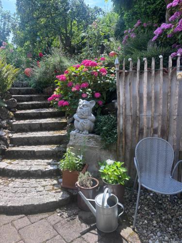 a garden with a fence and a chair and flowers at Bed & Breakfast Bodensee mit Herz in Stockach