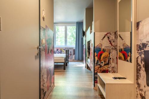 a hallway with paintings on the walls at a&o Hostel Venezia Mestre in Mestre