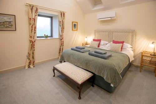 a bedroom with a large bed and a window at Converted Barn - Romantic Countryside Escape in Cupar