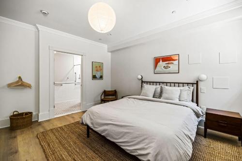 a white bedroom with a large bed and a bathroom at Suite 1A at Maison Dupont a Dupont Circle Inn in Washington, D.C.