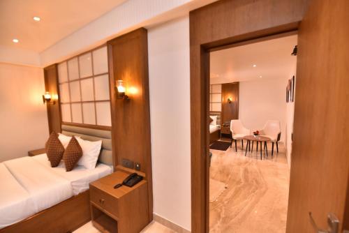 a hotel room with a bed and a dining room at Eennra Ssubarna in Baharampur