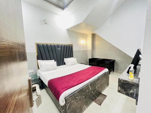 a bedroom with a bed with a red blanket at Hotel Royal Residency - Laxmi Nagar in New Delhi