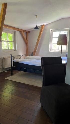 a bedroom with a bed and a chair in it at Alte Büdnerei - DZ "Bambus" in Brunshaupten