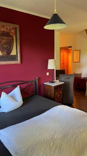 a bedroom with a bed and a red wall at Alte Büdnerei - DZ "Bambus" in Brunshaupten