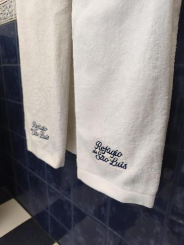 two towels with the words bathroom shine bills on them at Refugio de São Luis in São Luis