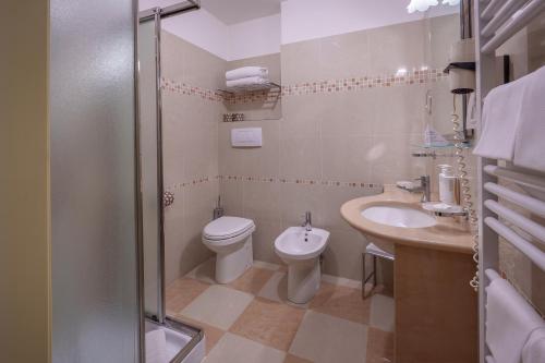 a bathroom with a toilet and a sink and a shower at Hotel & Meeting Centergross in Bentivoglio