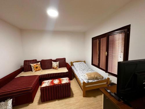 a living room with a couch and a tv at Weekend House in Vrelo in Jelovica