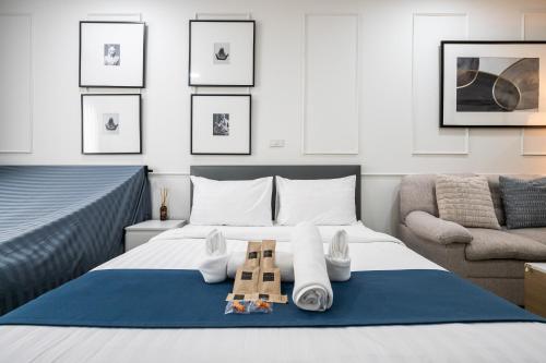 a bedroom with a bed with towels and a chair at Arun Sa Wad - Chinatown House in Bangkok