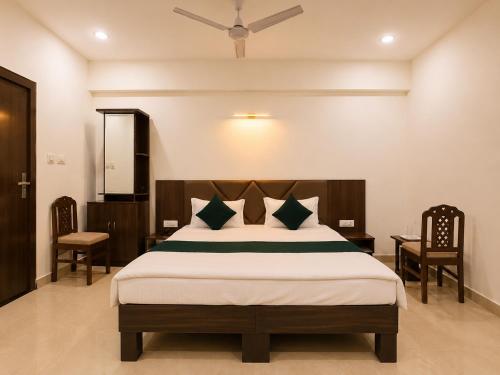 a bedroom with a bed and two chairs at Hotel Pragati Palace in Mathura