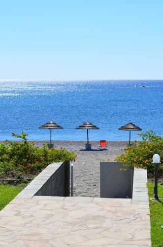 a beach with umbrellas and chairs and the ocean at Private beach villa Princess in Kiotari