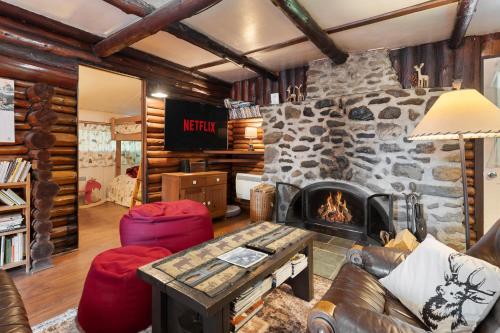 a living room with a fireplace and a stone wall at Spa Nature & Mountain - Le Pinacle in Frelighsburg