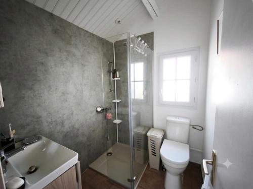 a bathroom with a shower and a toilet and a sink at Sur les dunes in La Guérinière