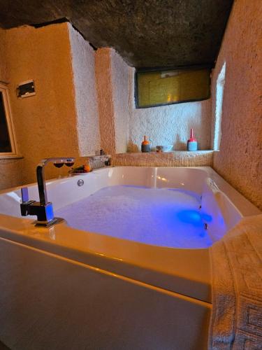 a large bath tub with a faucet in a bathroom at novela in stone house in Uçhisar