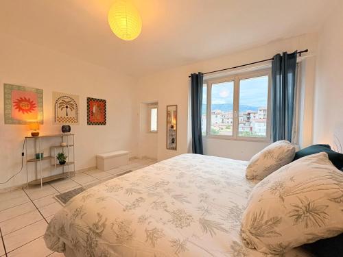 a bedroom with a large bed and a window at L'Observatoire Vue Château in Foix