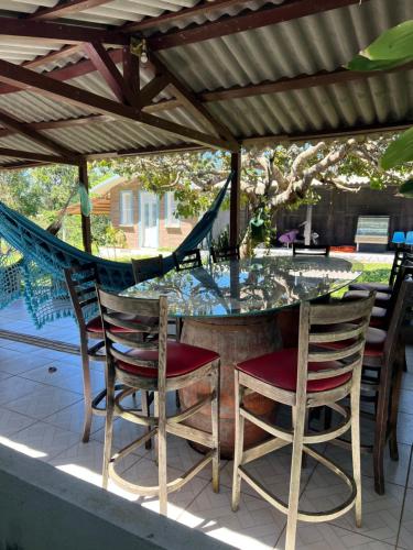 a patio with a table and chairs and a hammock at Pousada e Museu JK in Ubajara