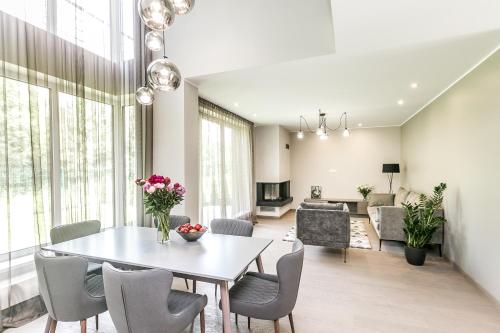 a dining room and living room with a table and chairs at Imanta Garden Townhouses in Riga