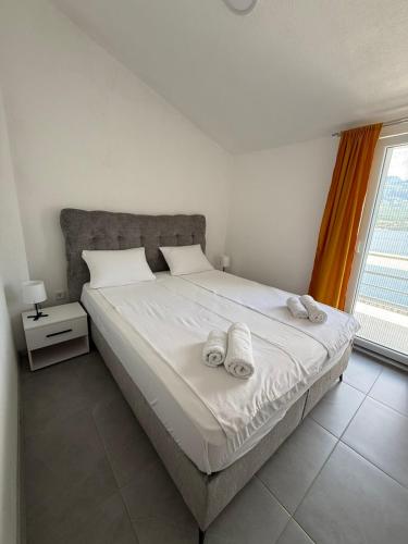 a bedroom with a bed with towels on it at Ivanović smeštaj in Rose