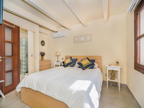 a bedroom with a large white bed with blue pillows at 3-Bed Villa with Pool, Puerto Pollença in Port de Pollensa