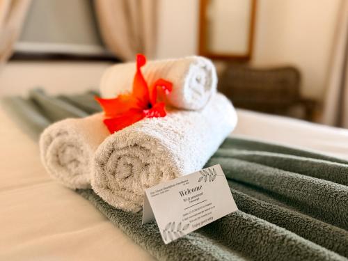 a pile of towels sitting on top of a bed at Far Niente Beachfront Guesthouse in Wilderness
