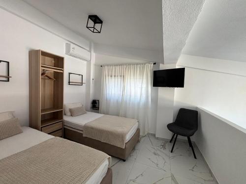 a bedroom with two beds and a chair in it at Anastasia B in Ofrínion
