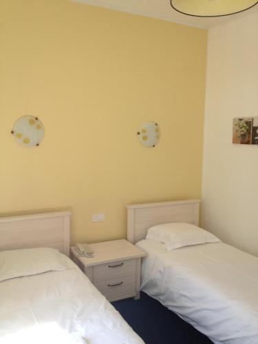 two beds sitting next to each other in a room at Hotel Couleurs Sud Centre-ville Gare Charleville-Mézières in Charleville-Mézières