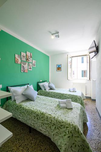 two beds in a room with green walls at Dimora l'Arancio in Lucca