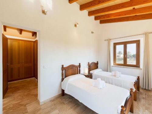 a room with three beds and a window at Modern Rustic Country Villa with Pool in Lloseta