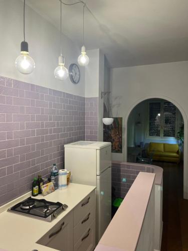 a kitchen with a white refrigerator and pink tiles at Matilde house in Montecatini Terme